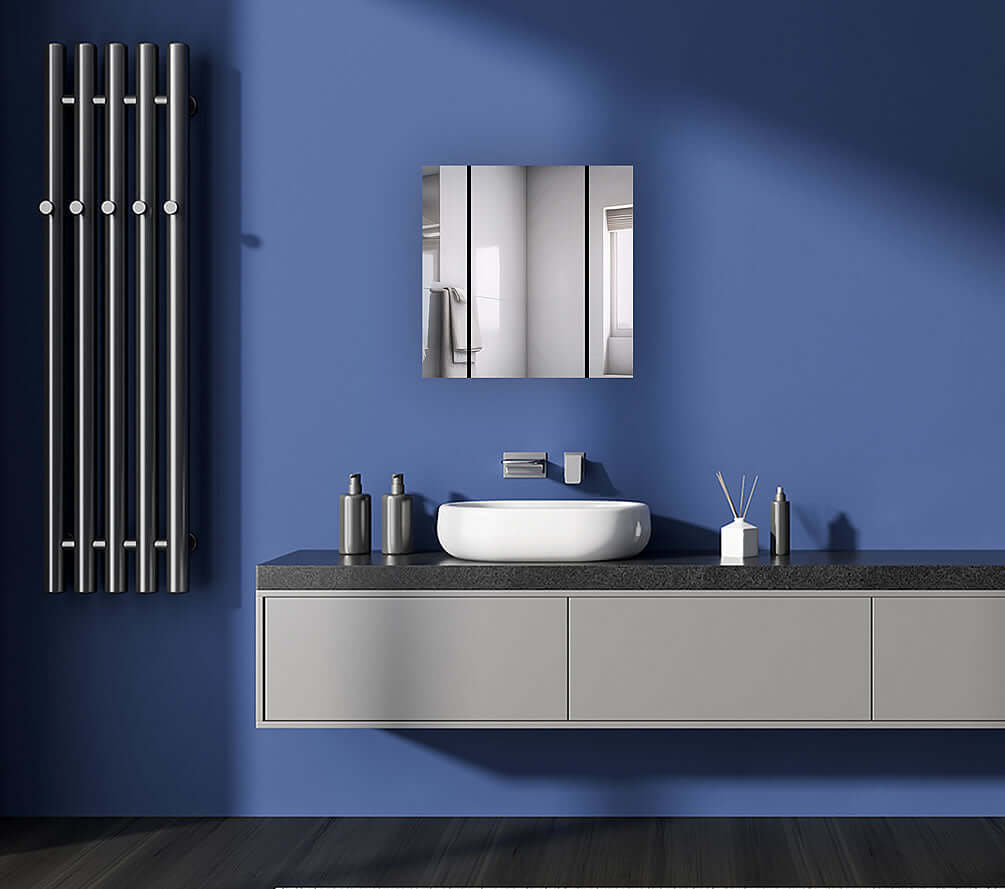 Aquadom Royale 3-Door Medicine Cabinet displayed in a modern bathroom setting with blue walls and contemporary fixtures.